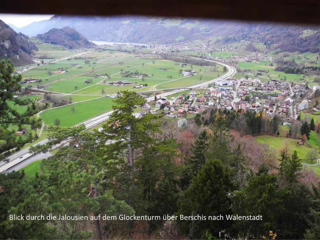 Blick durch die Jalousien auf dem Glockenturm über Berschis nach Walenstadt