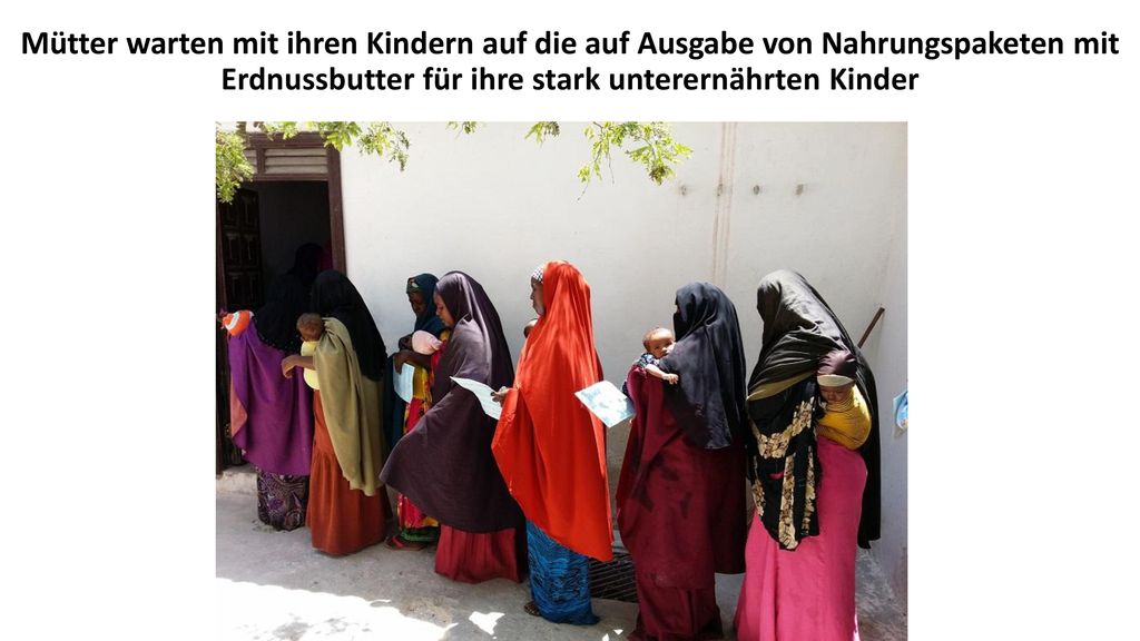 Mütter warten mit ihren Kindern auf die auf Ausgabe von Nahrungspaketen mit Erdnussbutter für ihre stark unterernährten Kinder