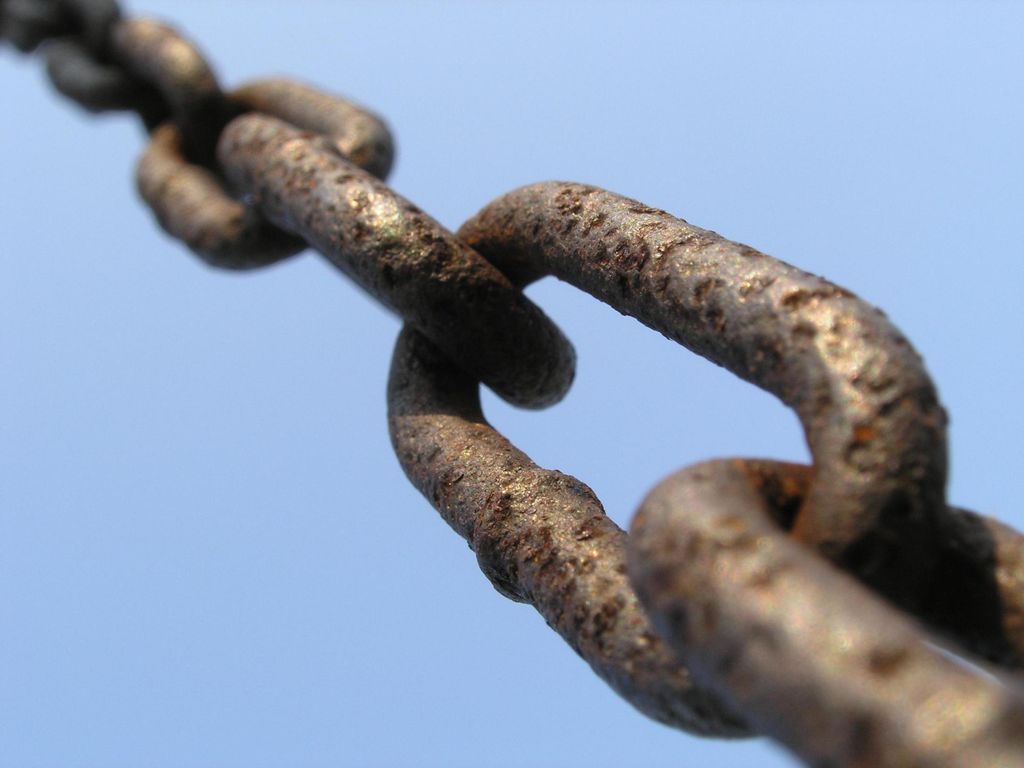 Der Bildhauer arbeitet von einer Hebebühne aus, die an einer zehngliedrigen Kette hängt. Er schaut auf und sieht, wie ein anderer Mann mit einer Metallsäge sägt. Er ruft: „Was machen Sie da