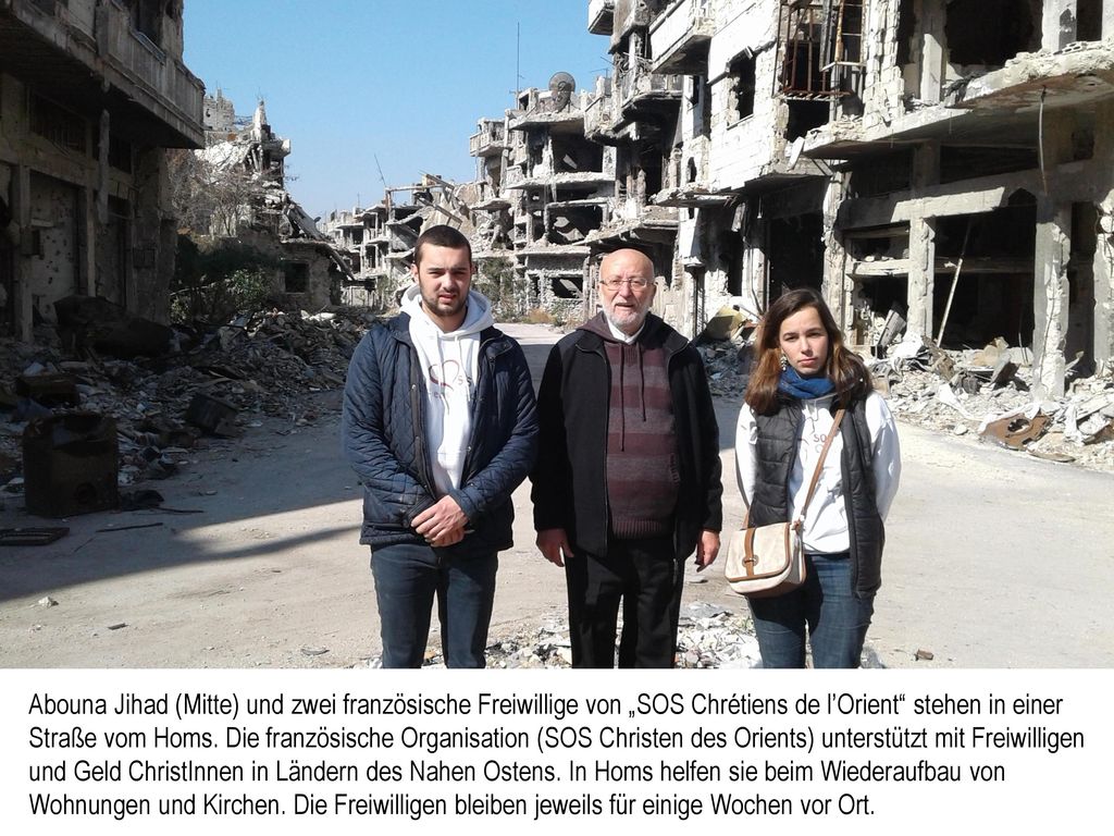 Abouna Jihad (Mitte) und zwei französische Freiwillige von „SOS Chrétiens de l’Orient stehen in einer Straße vom Homs.