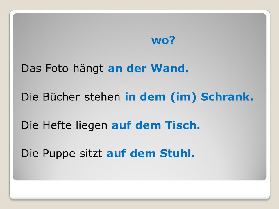 wo. Das Foto hängt an der Wand. Die Bücher stehen in dem (im) Schrank