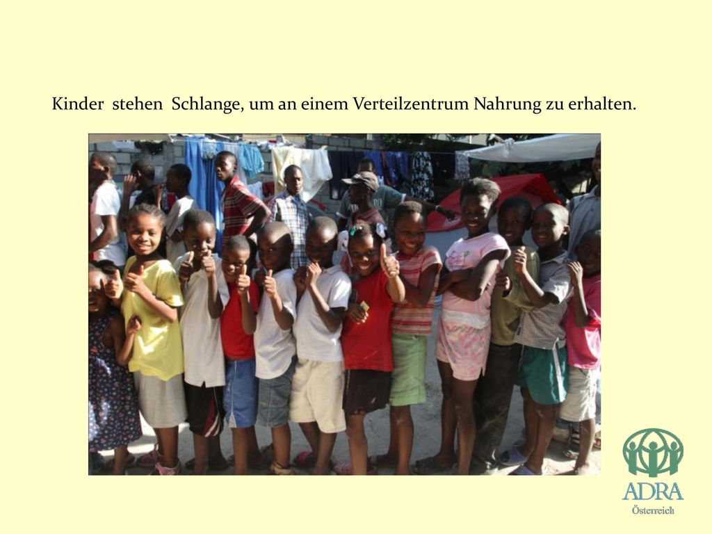Kinder stehen Schlange, um an einem Verteilzentrum Nahrung zu erhalten.