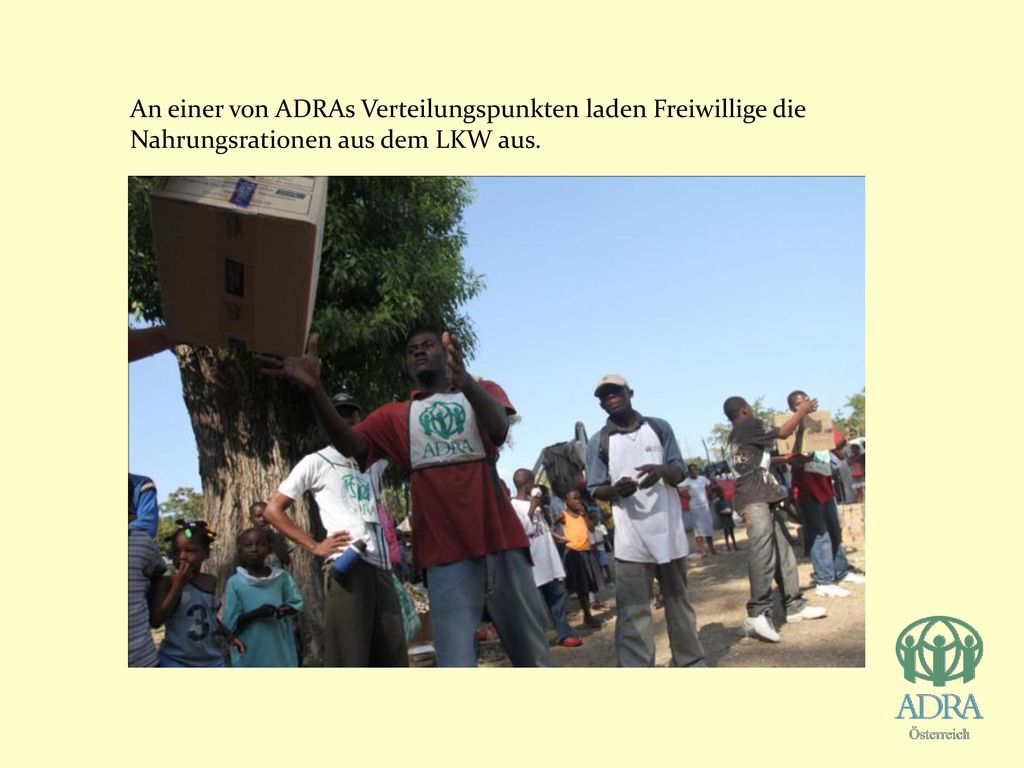 An einer von ADRAs Verteilungspunkten laden Freiwillige die Nahrungsrationen aus dem LKW aus.