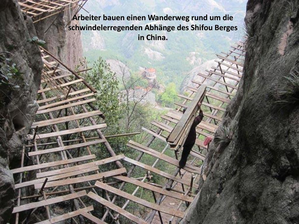 Arbeiter bauen einen Wanderweg rund um die schwindelerregenden Abhänge des Shifou Berges in China.