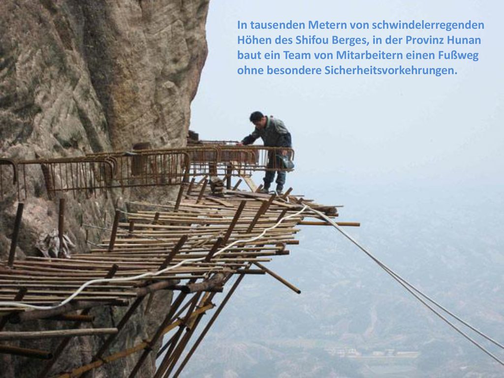 In tausenden Metern von schwindelerregenden Höhen des Shifou Berges, in der Provinz Hunan baut ein Team von Mitarbeitern einen Fußweg ohne besondere Sicherheitsvorkehrungen.